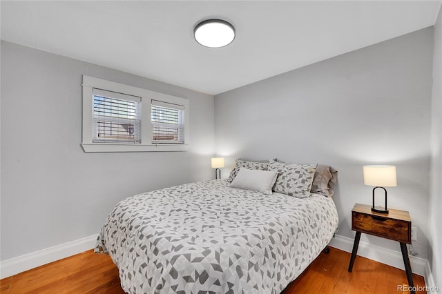 bedroom with wood finished floors and baseboards