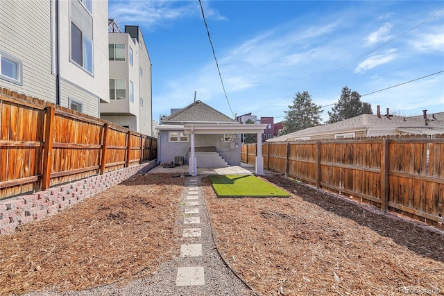 view of yard with central air condition unit and a fenced backyard