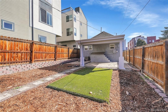 rear view of property featuring stucco siding, a patio, and a fenced backyard