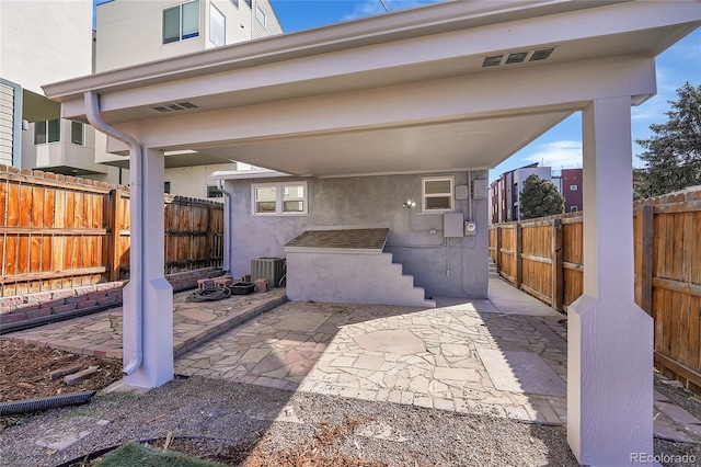 view of patio featuring cooling unit, a fenced backyard, and visible vents