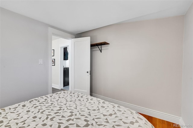 bedroom featuring baseboards and wood finished floors