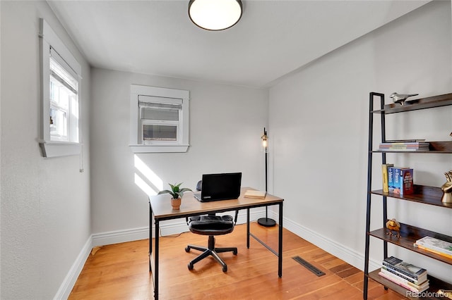 office space with visible vents, baseboards, and light wood finished floors