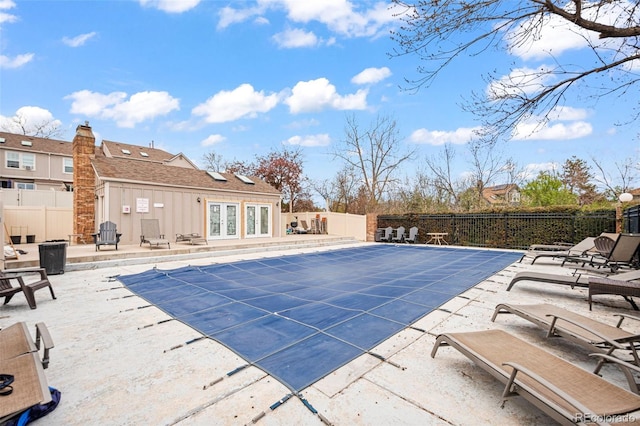 view of pool with french doors, a patio area, and fence