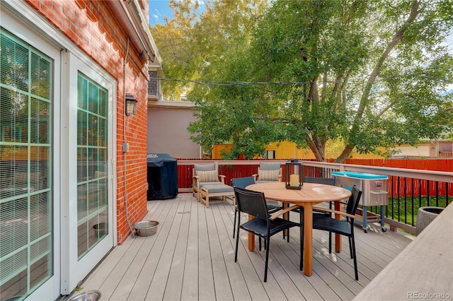 deck featuring outdoor dining space and fence