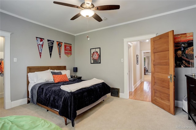 bedroom with ornamental molding, visible vents, light carpet, and baseboards