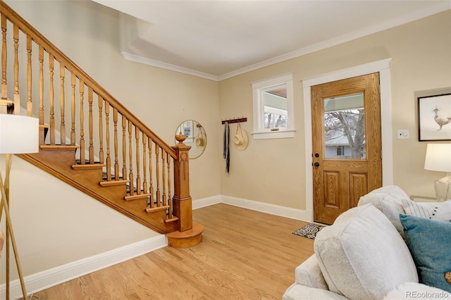 foyer entrance featuring crown molding, stairway, baseboards, and wood finished floors