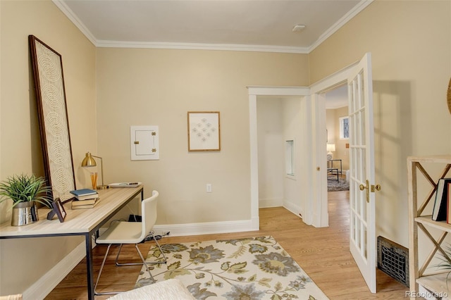 home office with french doors, visible vents, light wood-style floors, ornamental molding, and baseboards