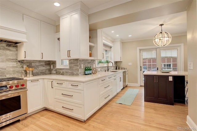 kitchen with custom range hood, stainless steel appliances, a sink, and light countertops