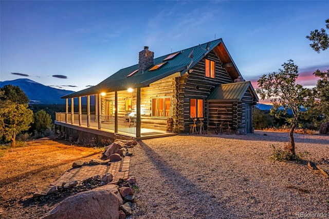 property exterior at dusk with a patio and a mountain view