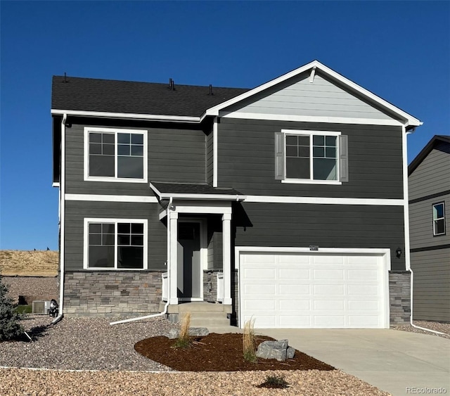 view of front of property with central AC unit and a garage