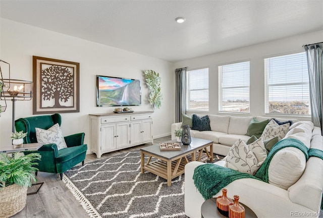 living room with an inviting chandelier and light hardwood / wood-style flooring