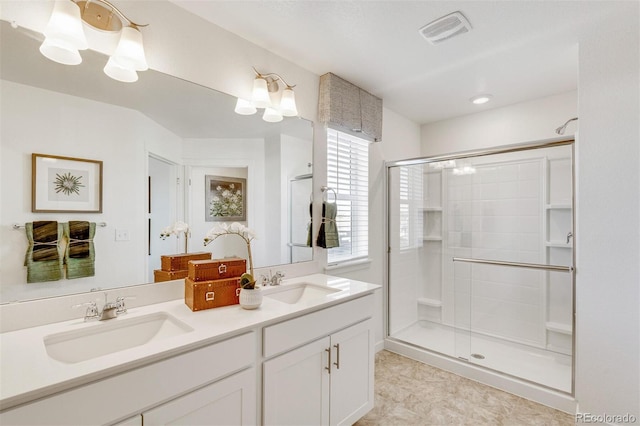 bathroom featuring tile patterned flooring, vanity, and a shower with shower door