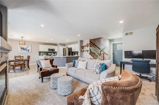 living area with recessed lighting, visible vents, stairs, and an inviting chandelier