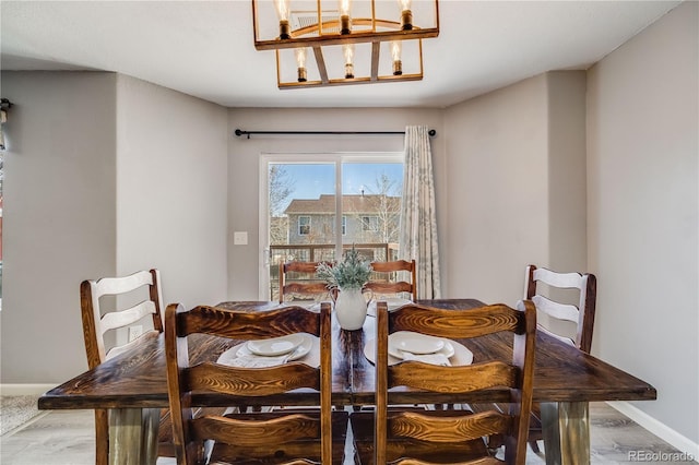 dining room featuring an inviting chandelier, wood finished floors, and baseboards