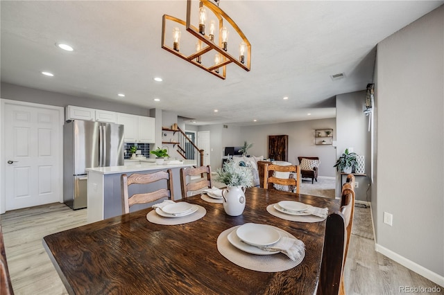 dining space featuring recessed lighting, light wood-style floors, stairs, and baseboards