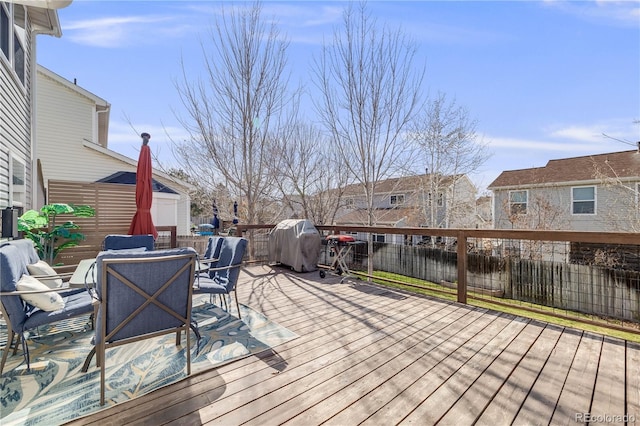 deck featuring area for grilling, a residential view, a fenced backyard, and outdoor dining space