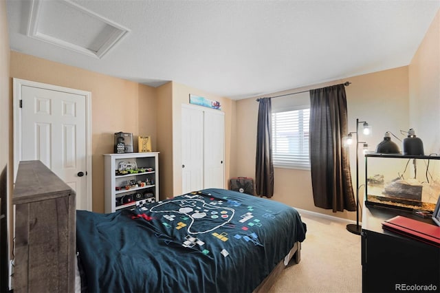 bedroom with a closet, attic access, and light carpet