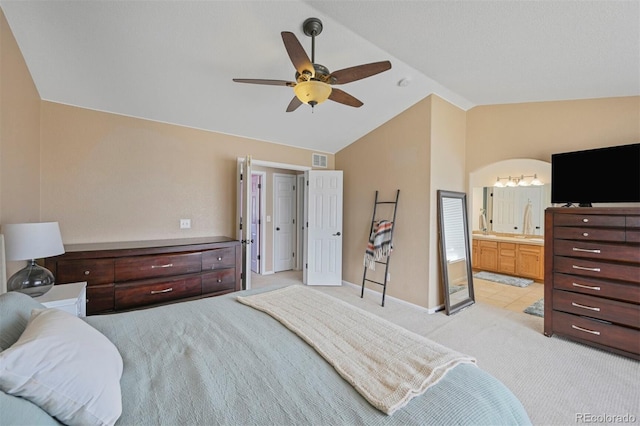 bedroom with ensuite bath, a ceiling fan, visible vents, lofted ceiling, and light colored carpet