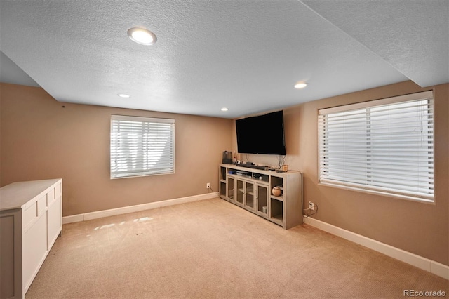 below grade area with recessed lighting, a textured ceiling, baseboards, and carpet floors