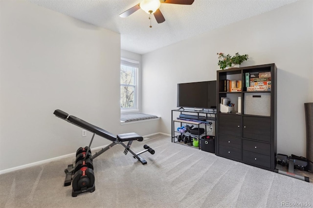 workout area with a ceiling fan, baseboards, a textured ceiling, and carpet flooring