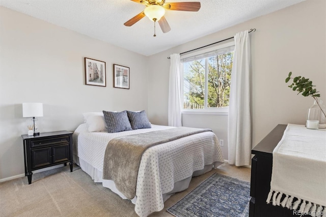 bedroom featuring a ceiling fan, light colored carpet, baseboards, and a textured ceiling