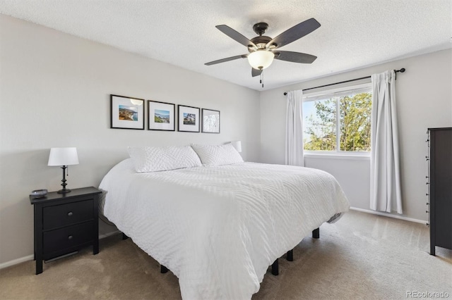 carpeted bedroom with ceiling fan, baseboards, and a textured ceiling