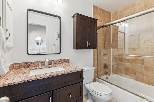 full bathroom with enclosed tub / shower combo, toilet, and vanity