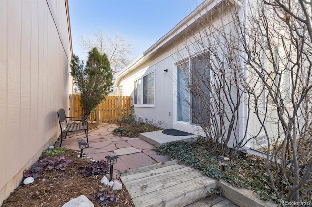 view of side of home featuring a patio area and fence