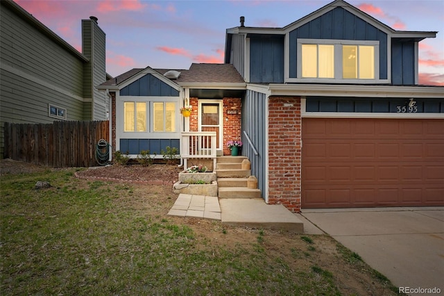 3593 S Gibralter Cir, Aurora, CO 80013 - view of front facade featuring board and batten siding, a garage, driveway, and brick siding