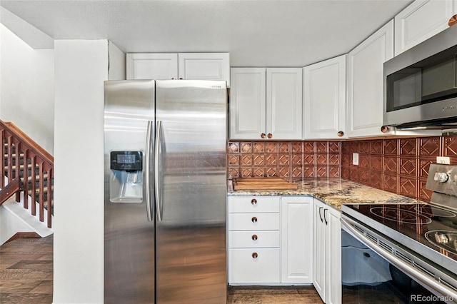 3593 S Gibralter Cir, Aurora, CO 80013 - kitchen featuring stainless steel appliances, light stone counters, white cabinetry, tasteful backsplash, and dark wood-style floors