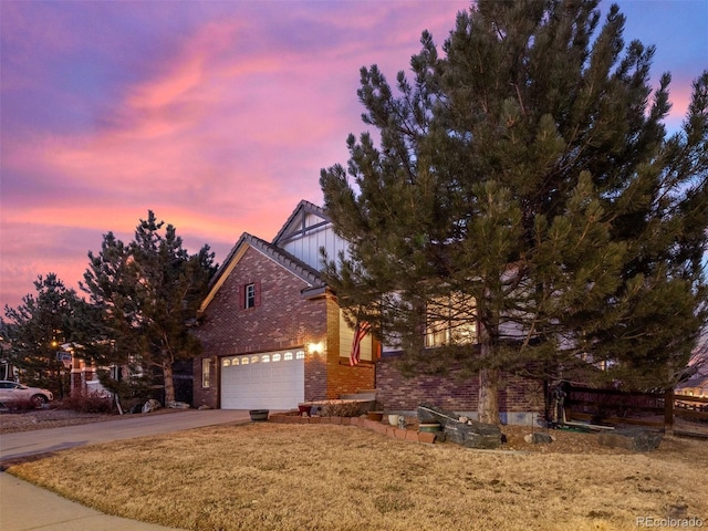 view of front facade with driveway, a front yard, board and batten siding, and brick siding