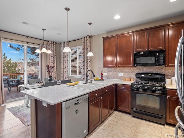 kitchen featuring a peninsula, a sink, light countertops, backsplash, and black appliances