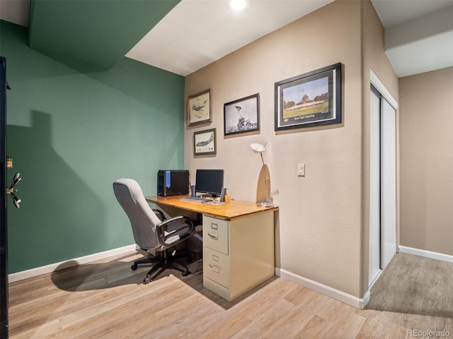 home office with light wood-style floors and baseboards