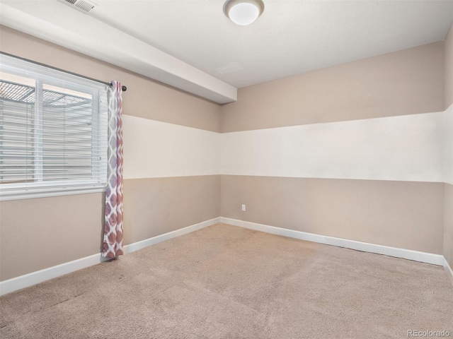 unfurnished room featuring carpet, visible vents, and baseboards