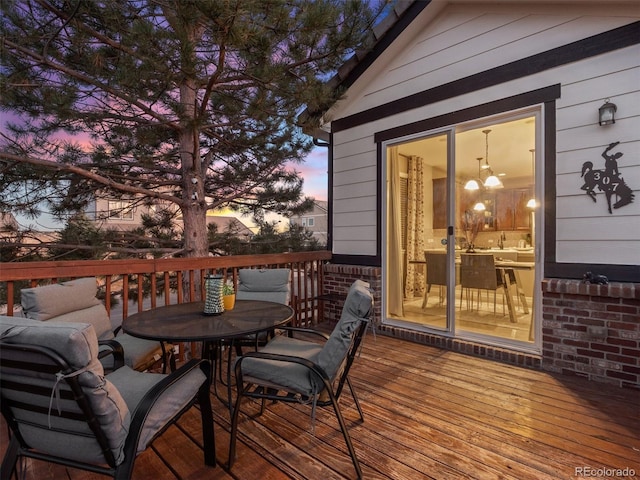 deck at dusk with outdoor dining space