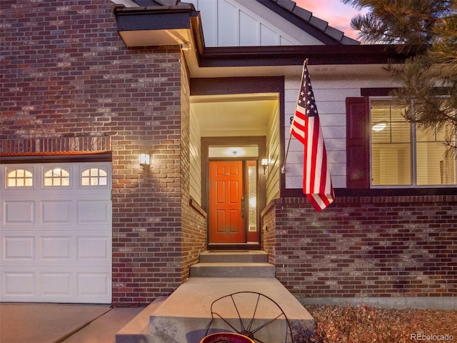 property entrance with brick siding, board and batten siding, and an attached garage