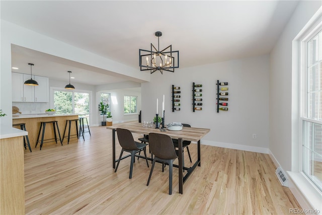 dining area featuring light hardwood / wood-style flooring and a chandelier