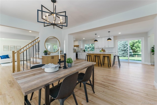 dining space with a notable chandelier and light hardwood / wood-style flooring