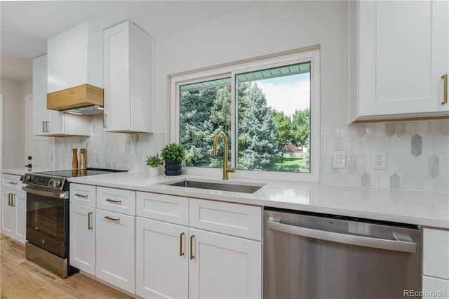 kitchen with white cabinetry, appliances with stainless steel finishes, sink, and backsplash