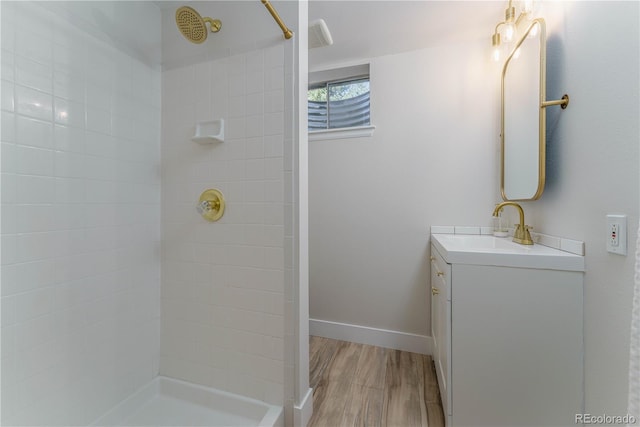 bathroom with vanity, wood-type flooring, and tiled shower