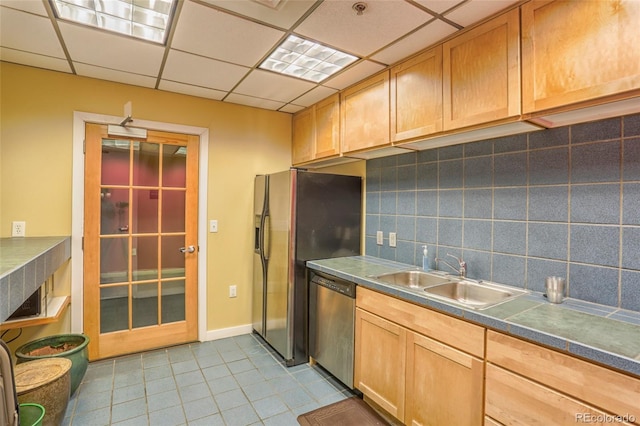 275 S Harrison St Unit 409, Denver, CO 80209 - kitchen featuring stainless steel dishwasher, backsplash, light tile patterned floors, and a drop ceiling