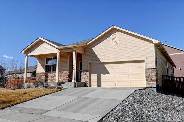 view of front facade with stone siding, a porch, fence, concrete driveway, and a garage