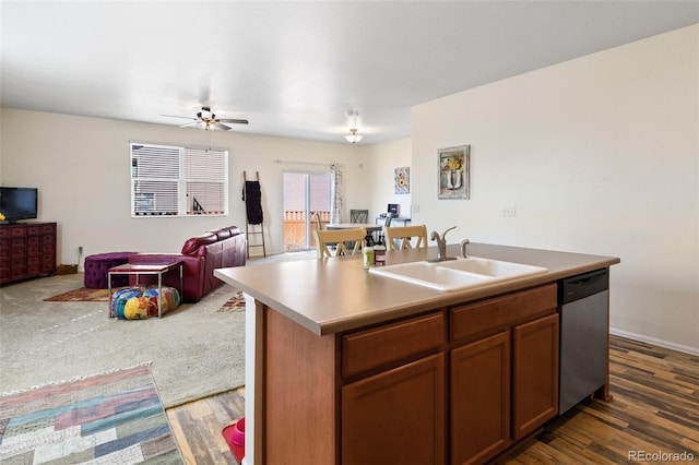 kitchen with an island with sink, a sink, stainless steel dishwasher, open floor plan, and light countertops