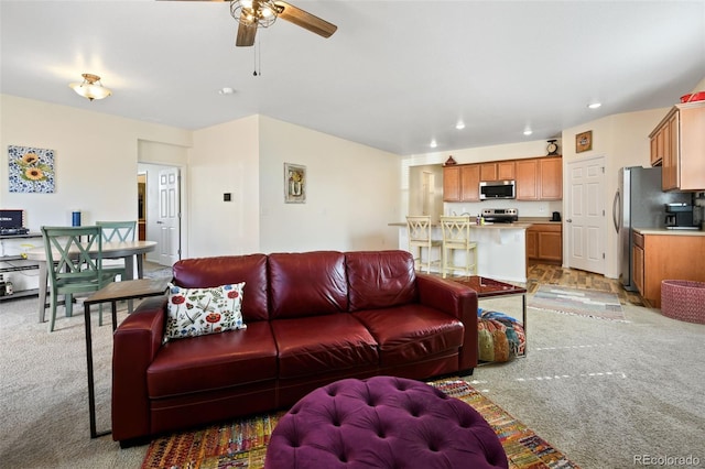 living area featuring a ceiling fan, recessed lighting, and light colored carpet