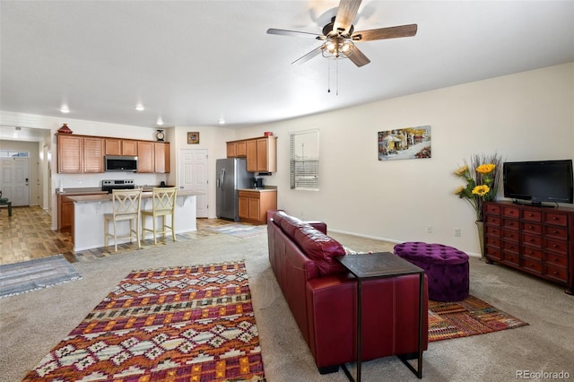 living area featuring recessed lighting, light colored carpet, baseboards, and a ceiling fan