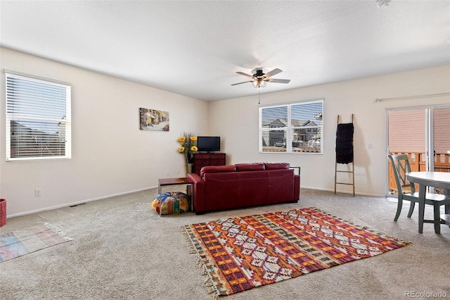 living area with baseboards, carpet floors, and ceiling fan