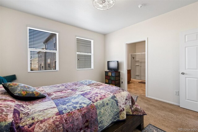 bedroom with light colored carpet, baseboards, and ensuite bathroom