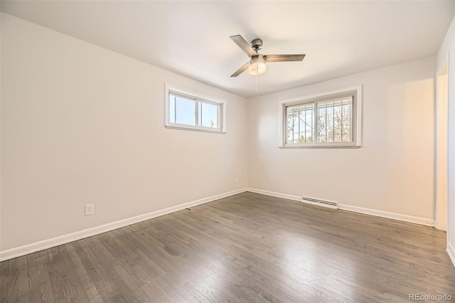 empty room with a ceiling fan, baseboards, and wood finished floors