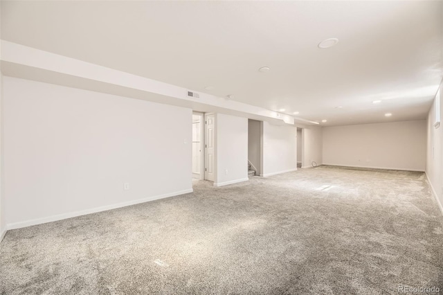 empty room with light carpet, stairway, baseboards, and recessed lighting