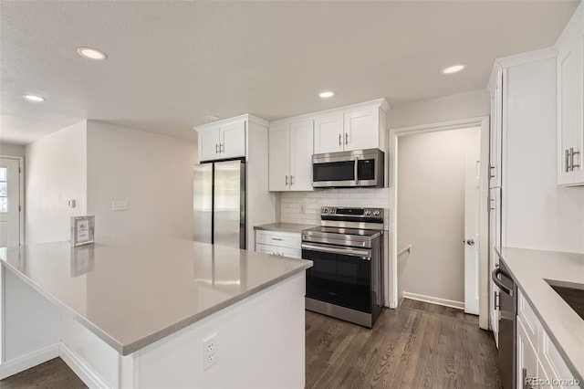 kitchen featuring appliances with stainless steel finishes, white cabinets, dark wood-style flooring, light countertops, and recessed lighting